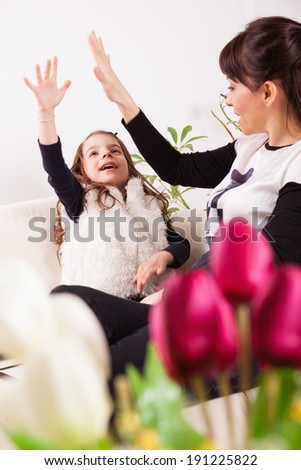 Cute little girl and her mother for Mother\'s day. Focus is on flowers.