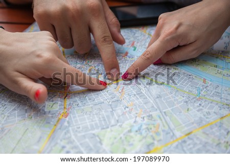 Three Young Tourists Pointing On Map