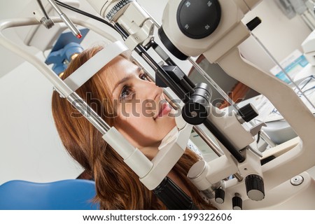 Young Woman Looking Into Eye Test Machine