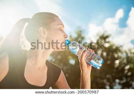 Beautiful Young Woman Drinking Water After Training