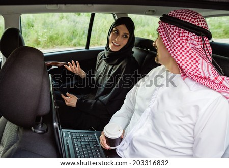 Arabian Businessman And Businesswoman Traveling In The Car And Using Technology