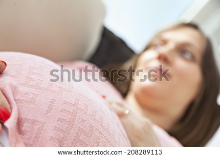 Beautiful Pregnant Woman Embracing Her Belly. Focus Is On Belly