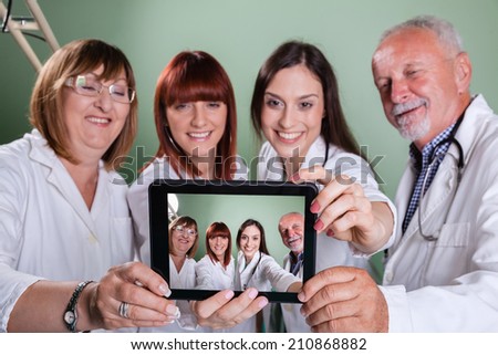 Smiling Team Of Doctors And Nurses At Hospital Taking Selfie Using Digital Tablet