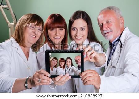 Smiling Team Of Doctors And Nurses At Hospital Taking Selfie Using Digital Tablet