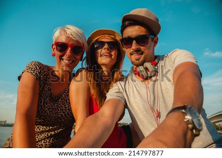 Three Young Hipster Friends Near River Taking Selfie