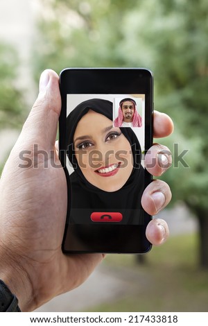 Close Up Of Arabian Male Hand Holding A Smart Phone During A Video Call With His Wife