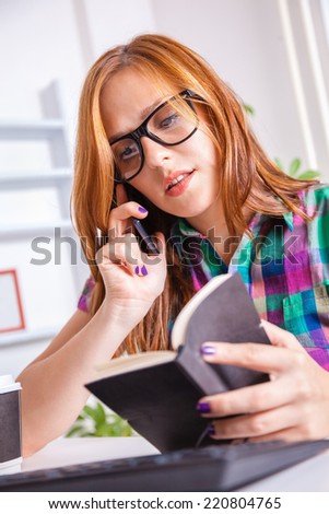 Young Female Graphic Designer In Office Having Phone Conversation