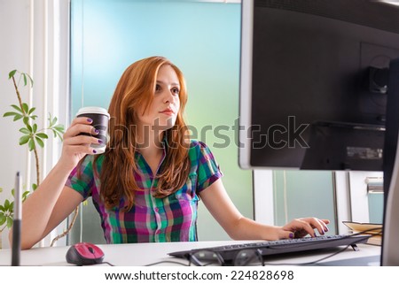 Young Female Graphic Designer Drinking Coffee And Working In Office