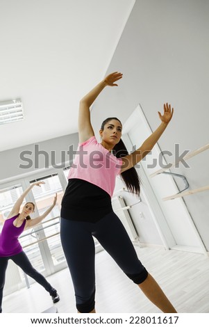 Young Women In A Gym Warming Up With Gymnastics And Stretching Exercises