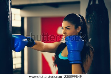 Attractive Female Punching A Bag With Boxing Gloves On