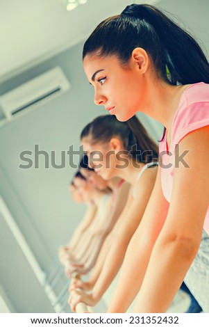 Young Women In A Gym Warming Up With Gymnastics And Stretching Exercises