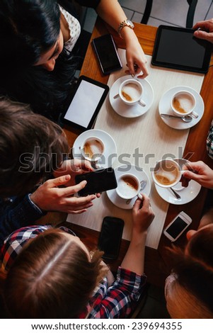 Group Of Young Friends Drinking Coffee In Cafe. View From above