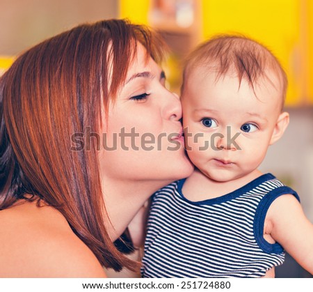Happy Mother Kissing Adorable Baby Boy