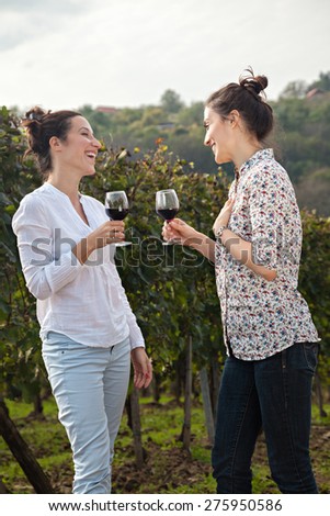 Two Beautiful Young Women Drinking Wine  In Vineyard
