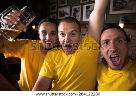 A Group Of Excited Friends Cheering On Their Favorite Team At The Bar