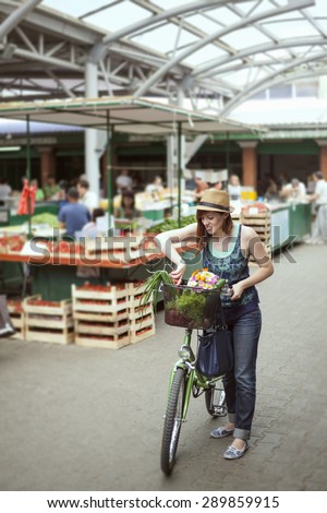 Female At Market Place With Basket Full Of Vegetables And Bouquet Of Flowers