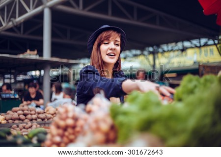 Young Female Looking For Some Vegetables At Market Place