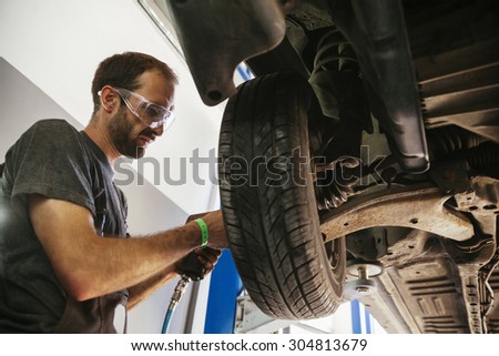 Auto Mechanic Working In Garage. Repair Service
