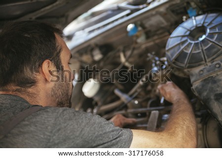 Auto Mechanic Fixing Car In A Workshop