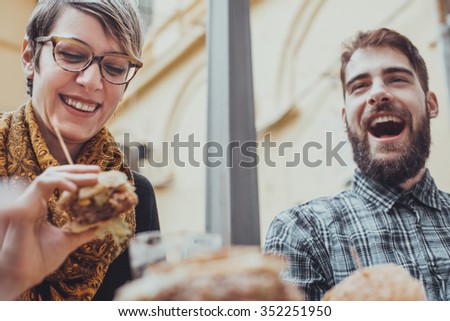Hipster Friends In Fast Food Reastaurant Eating Burgers