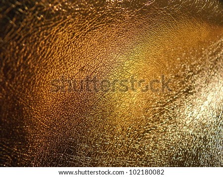 Golden, glossy, elegant, evening leather texture close up. Good for fashion, disco, party, carnival, evening, interior or industrial design.