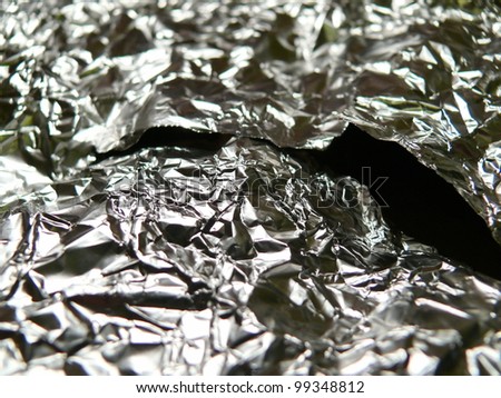 Metallic, crumpled, metallic, aluminum texture close up. Good for kitchen, abstract, industrial, ecology or conceptual designs.
