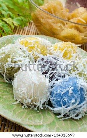 Thai dessert for rituals and eating. Flour stuffed with sweet coconut, and grated coconut topping on plate.