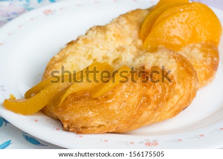 Danish Peach pastry on plate with sliced ??peaches