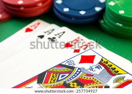 Various value poker chips on background showing a poker hand of a full house kings over aces.