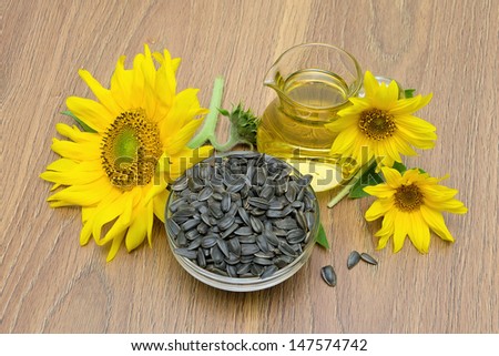 sunflower seeds and flowers, sunflower oil on board. top view - horizontal photo.