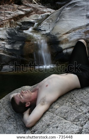 model on rock infront of waterfall