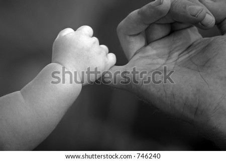 baby holding fathers hand