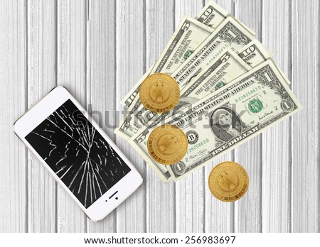 Modern broken mobile phone and dollars on white wooden background
