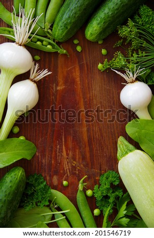 Fresh green vegetables and herbs on a dark background. food background. book cover. space for text. frame of vegetables.
