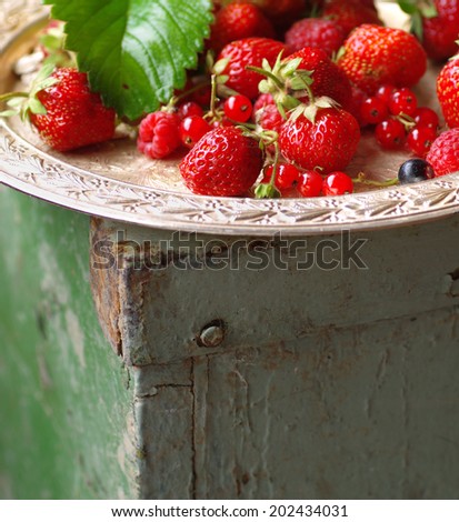 Fresh berries on old vintage tray. Ripe red berries. Red fruit.