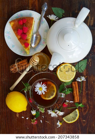 English tea party. Freshly brewed tea with lemon on a dark wooden table (top view). Tea party with cake.