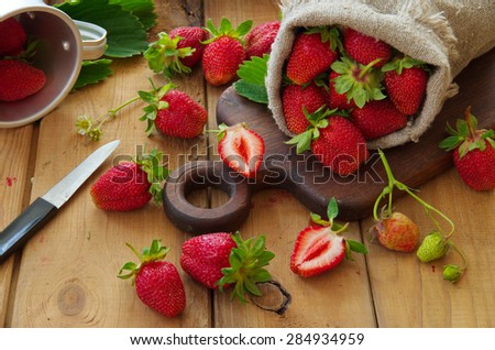 RURAL Still Life with Strawberries. Ripe strawberries in a sack. Harvest berries. Old wooden table.