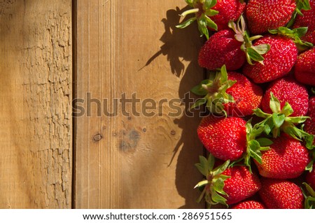 Ripe strawberries on an old wooden table. Harvest berries. Culinary background with fruit.