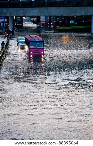 BANGKOK - NOVEMBER 5: Cars and a bus navigate through flood waters on Phahonyothin Road during the worst flooding in Bangkok, Thailand on November 5, 2011.