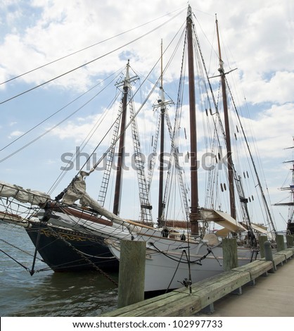 Two sailing ships, side by side, at dock.