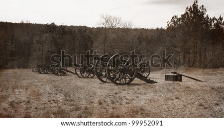 A vintage textured antique representation of an old photo of a battery of civil war cannon lined up for battle.