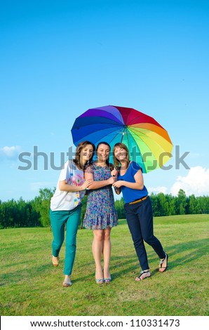 Three young girls with big umbrella