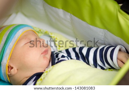 baby sleeping in a green towel in nature