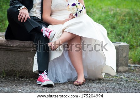 Bride and groom in bright clothes on the bench