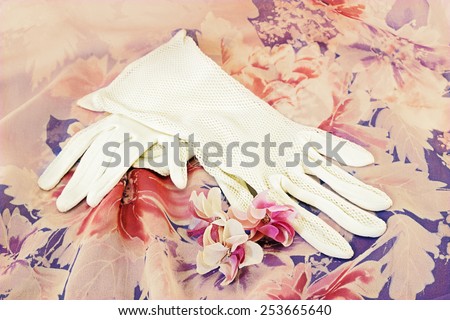 Vintage white gloves and artificial flowers on silk