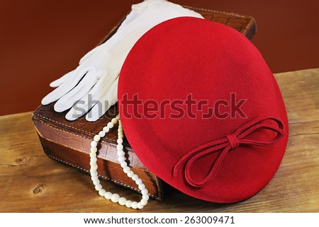 Red hat, white gloves and bone beads on leather case