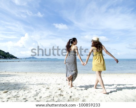 woman hang out together on sand beach with blue sky background
