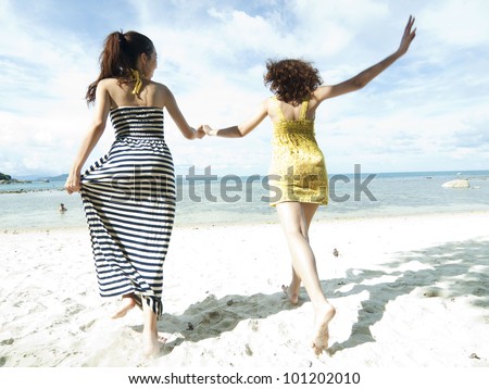 woman hang out  together sand by sea edge on blue sky background