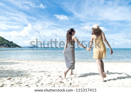 woman hang out together sand by sea edge on blue sky background