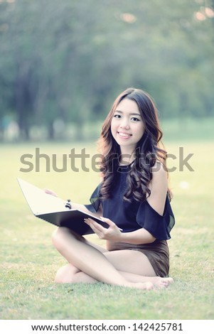 asia woman reading in the park (Vintage tone style)